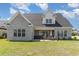 Spacious backyard showcasing a well-manicured lawn, patio with furniture, and pristine brick exterior at 801 Celene Ct., Myrtle Beach, SC 29579