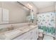 Bright bathroom features a double vanity with granite counters, large mirror, and shower-tub combo with decorative curtain at 801 Celene Ct., Myrtle Beach, SC 29579