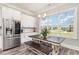 Bright kitchen featuring white cabinets, stainless steel refrigerator, and a dining table with outdoor view at 801 Celene Ct., Myrtle Beach, SC 29579