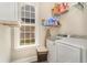 Bright laundry room with machines, storage shelving, a window, and a basket for clothes at 801 Celene Ct., Myrtle Beach, SC 29579