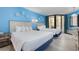Cozy bedroom featuring two beds, blue walls, and balcony access at 9550 Shore Dr. # 633, Myrtle Beach, SC 29572