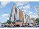A ground level exterior view of a high rise condo with palms and street parking at 9550 Shore Dr. # 633, Myrtle Beach, SC 29572