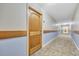 Hallway with tan carpet and light blue walls leading to wooden door at 9550 Shore Dr. # 633, Myrtle Beach, SC 29572