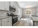 Contemporary kitchen featuring stainless steel appliances, gray wood flooring, and abundant natural light at 108 Old Chimney Ln, Conway, SC 29526
