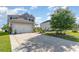 Exterior view showing a large driveway leading to a well-maintained two-story home with lush landscaping at 1313 Cascarilla Ct., Myrtle Beach, SC 29579
