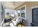 Comfortable screened porch features cozy seating, ceiling fan, and views of the yard at 1313 Cascarilla Ct., Myrtle Beach, SC 29579