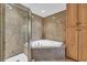 Bathroom includes glass shower, jacuzzi soaking tub, wood cabinets, and designer granite countertops at 1352 Villa Marbella Ct. # 1-204, Myrtle Beach, SC 29572