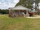 Charming brick home with a covered porch and well-manicured lawn featuring vibrant red flowers at 1465 Dirty Branch Rd., Conway, SC 29527