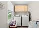Functional laundry room with washer, dryer, storage cabinets, and a bright window at 1506 7Th Ave., Conway, SC 29526