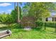 Backyard shed with wooden facade, situated in a lush yard, surrounded by fencing for secure storage at 1506 7Th Ave., Conway, SC 29526