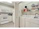 Convenient laundry area with white washer and dryer, open shelving, and adjoining kitchen space at 1533 Lanterns Rest Rd. # 304, Myrtle Beach, SC 29579