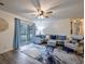 Living room features gray sectional with blue pillows, a ceiling fan, and access to outdoor space at 193 Charter Dr. # E-2, Longs, SC 29568