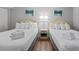 Cozy bedroom features two beds with fresh white linens and starfish artwork at 2000 N Ocean Blvd. # 502, Myrtle Beach, SC 29577