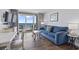 Cozy living room featuring a comfortable blue sofa and a view of the beach at 2000 N Ocean Blvd. # 502, Myrtle Beach, SC 29577
