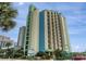 Brightly painted high-rise condo building with balconies and palm trees set against a blue sky at 2310 N Ocean Blvd. # 308, Myrtle Beach, SC 29572
