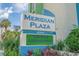 Meridian Plaza building sign surrounded by bright flowers and lush shrubbery at 2310 N Ocean Blvd. # 308, Myrtle Beach, SC 29572