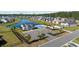 Aerial view of the community clubhouse, pool, and pond surrounded by beautiful homes at 237 Copperwood Loop, Conway, SC 29526