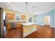 Open kitchen with granite countertops, stainless appliances, wood floors, and decorative lighting at 237 Copperwood Loop, Conway, SC 29526