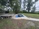 Backyard pool needing maintenance and cover set in a spacious grassy yard surrounded by mature trees at 2560 Wise Rd., Conway, SC 29526