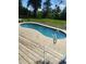 Backyard pool with wooden deck and landscaped yard, offering an inviting outdoor space for leisure and recreation at 2560 Wise Rd., Conway, SC 29526