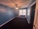 Bedroom featuring blue walls, dark carpet, a ceiling fan, and a window with curtains at 2560 Wise Rd., Conway, SC 29526