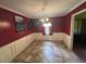 Dining room featuring red walls, white wainscoting, tile flooring, and a chandelier at 2560 Wise Rd., Conway, SC 29526