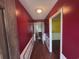 Hallway with red walls, white trim, and wood-look flooring leading to other rooms at 2560 Wise Rd., Conway, SC 29526
