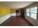 Spacious living room with yellow walls, white trim, wood-look flooring, and large windows at 2560 Wise Rd., Conway, SC 29526