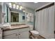 Well-lit bathroom featuring a granite vanity, ample storage, and shower with curtain at 2711 S Ocean Blvd. # 1917, North Myrtle Beach, SC 29582