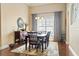 Dining room with hardwood floors, a stylish mirror, and a large window with decorative curtains at 3053 Chesterwood Ct., Myrtle Beach, SC 29579