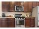 Close up of kitchen features stainless steel appliances, granite countertops, and dark wood cabinetry at 3053 Chesterwood Ct., Myrtle Beach, SC 29579