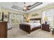 Main bedroom with tray ceiling, large window, bedside tables, and hardwood furnishings at 3053 Chesterwood Ct., Myrtle Beach, SC 29579