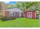 Backyard with well-maintained lawn, a red shed, and mature landscaping at 311 Surfside Dr., Surfside Beach, SC 29575