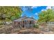 View of the brick home exterior with a screened in porch, fenced yard and trees at 311 Surfside Dr., Surfside Beach, SC 29575