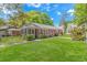 Brick home with metal roof, screen porch, fenced yard, and mature landscaping at 311 Surfside Dr., Surfside Beach, SC 29575