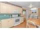 Traditional kitchen with cream-colored cabinets and countertops, and adjacent dining area at 311 Surfside Dr., Surfside Beach, SC 29575