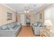 Cozy living room features two gray couches, wood flooring, and a decorative ceiling fan at 311 Surfside Dr., Surfside Beach, SC 29575