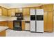 Practical kitchen with wood cabinets, white appliances, and tile flooring offering ample space for culinary tasks at 412 43Rd Ave. N, Myrtle Beach, SC 29577