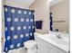 Bathroom showcasing a toilet and a sink with white cabinets and a blue shower curtain at 4430 Eastport Blvd. # L15, Little River, SC 29566