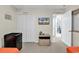 Well-lit bedroom features a mini-fridge, a TV, closet, and an adjacent doorway leading to other parts of the home at 4430 Eastport Blvd. # L15, Little River, SC 29566