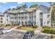 Three-story building with multiple units, white balconies, and landscaped grounds and parking at 4430 Eastport Blvd. # L15, Little River, SC 29566