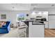 Open-concept kitchen with a bar, white cabinets, modern appliances, and seamless flow to the adjacent living area at 4430 Eastport Blvd. # L15, Little River, SC 29566