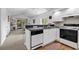 Kitchen open to living room featuring black appliances, white cabinets, and an eat-in bar at 4430 Eastport Blvd. # L15, Little River, SC 29566