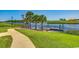 A grassy area with a curved sidewalk leading to a dock with a boat at 468 Saint Julian Ln., Myrtle Beach, SC 29579