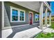 Inviting front porch showcasing a red door, classic columns, and a well-maintained concrete surface at 468 Saint Julian Ln., Myrtle Beach, SC 29579