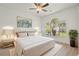 Staged bedroom featuring light wood floors, a ceiling fan, palm tree view, and stylish decor at 4683 Wild Iris Dr. # 204, Myrtle Beach, SC 29577