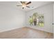 Bright bedroom featuring light wood floors, ceiling fan and a large window with palm tree views at 4683 Wild Iris Dr. # 204, Myrtle Beach, SC 29577