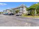 Exterior view of a multi-story condo complex with ample parking at 4683 Wild Iris Dr. # 204, Myrtle Beach, SC 29577