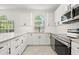 Modern white kitchen featuring stainless steel appliances, quartz countertops, and subway tile backsplash at 4683 Wild Iris Dr. # 204, Myrtle Beach, SC 29577