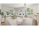 Bright staged living room featuring light wood floors, and ample seating with plush white furniture at 4683 Wild Iris Dr. # 204, Myrtle Beach, SC 29577